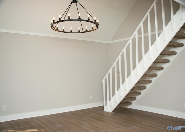 staircase with wood-type flooring and a notable chandelier