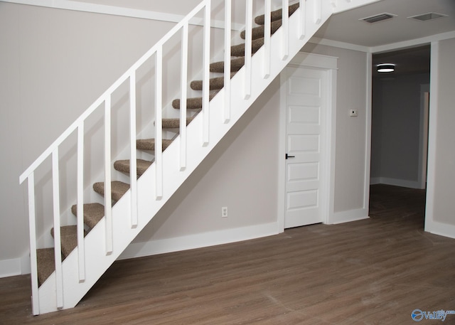 stairway with hardwood / wood-style flooring and crown molding