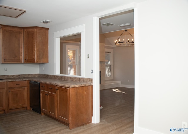 kitchen featuring a chandelier, a fireplace, light hardwood / wood-style floors, and decorative light fixtures