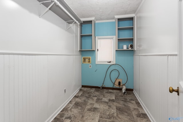 clothes washing area with a textured ceiling, crown molding, and hookup for a washing machine