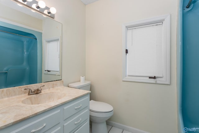 bathroom with tile patterned flooring, vanity, toilet, and walk in shower