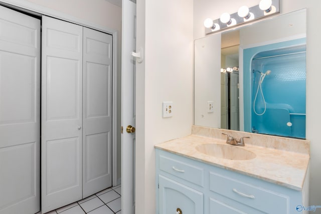 bathroom with a shower, vanity, and tile patterned flooring