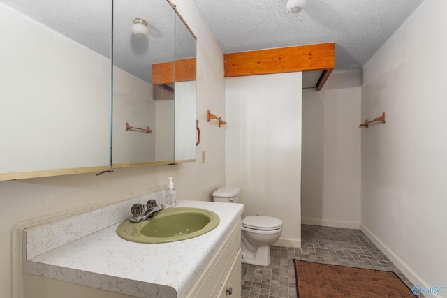 bathroom with vanity, a textured ceiling, and toilet