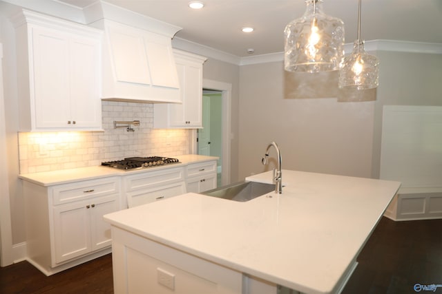 kitchen featuring sink, white cabinetry, an island with sink, decorative light fixtures, and stainless steel gas stovetop