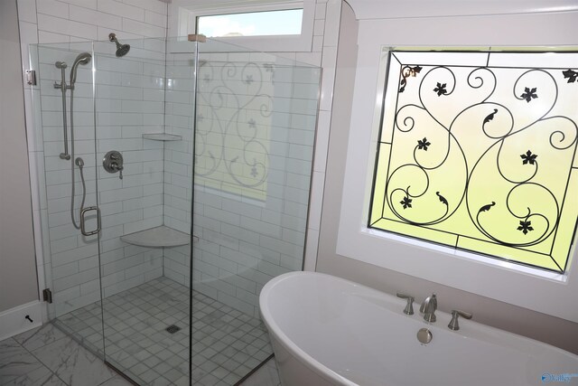 bathroom featuring shower with separate bathtub