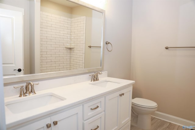 bathroom featuring vanity, hardwood / wood-style flooring, a shower, and toilet