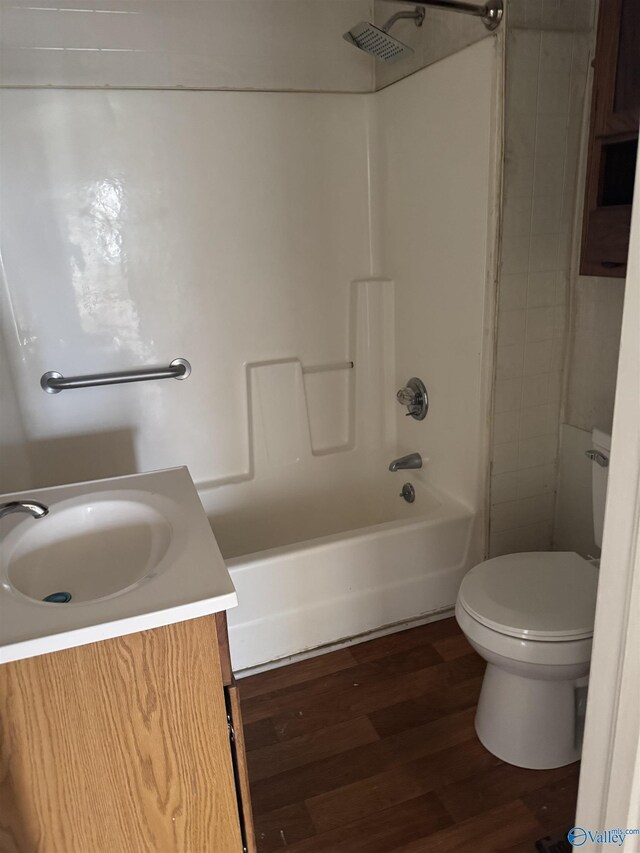 bathroom featuring vanity, toilet, wood finished floors, and shower / bath combination