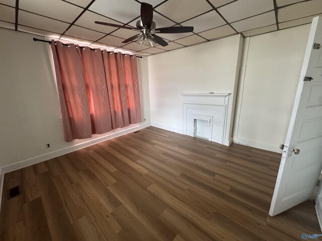 unfurnished living room with visible vents, a ceiling fan, wood finished floors, baseboards, and a paneled ceiling