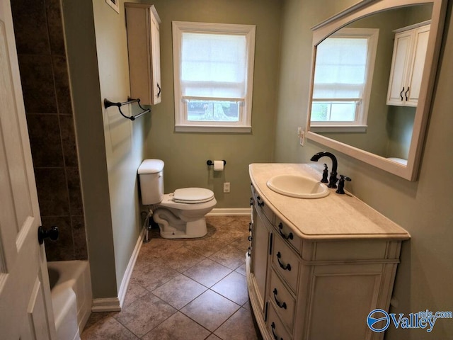 bathroom featuring vanity, a wealth of natural light, tile patterned floors, and toilet