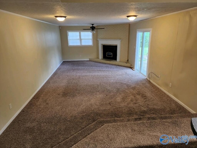 unfurnished living room with crown molding, a fireplace, carpet flooring, and a textured ceiling