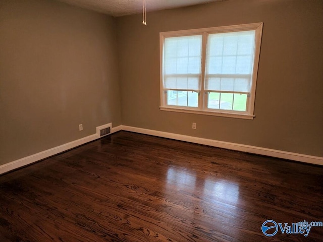 unfurnished room with dark hardwood / wood-style flooring