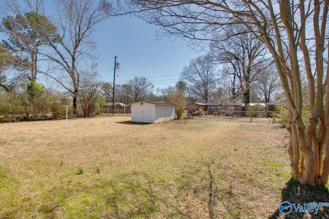 view of yard with an outdoor structure, fence, and a storage unit