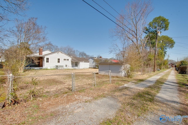 exterior space with a chimney, an outdoor structure, and fence