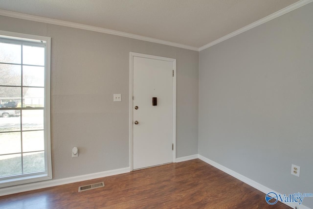 unfurnished room with a healthy amount of sunlight, dark wood-style floors, and visible vents