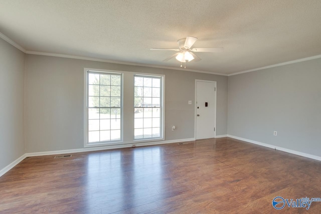 spare room featuring a textured ceiling, ornamental molding, wood finished floors, and visible vents