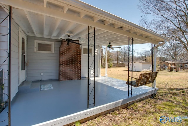 view of patio / terrace with a ceiling fan and an outbuilding