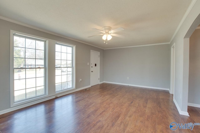 spare room with a ceiling fan, arched walkways, dark wood-style flooring, and crown molding