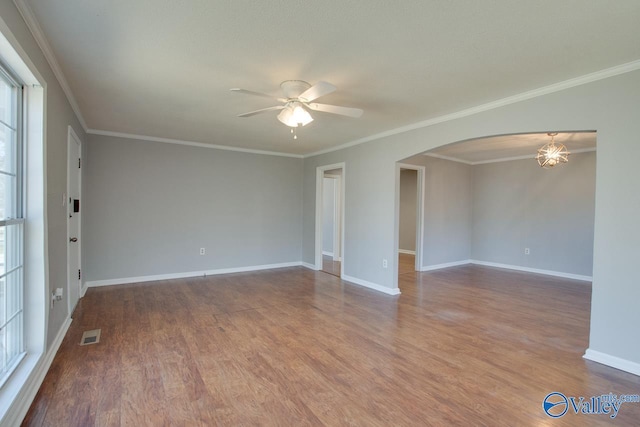 spare room featuring visible vents, arched walkways, ceiling fan, and wood finished floors