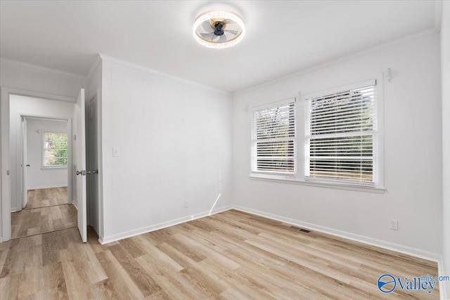 empty room featuring light hardwood / wood-style floors and ornamental molding