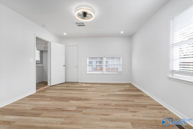 unfurnished bedroom with light hardwood / wood-style flooring and multiple windows