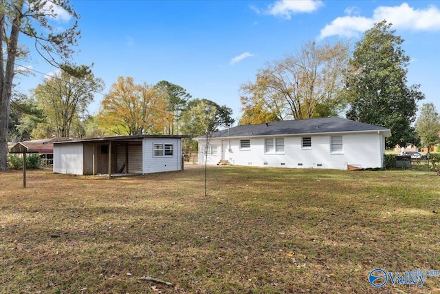 rear view of house with an outbuilding and a yard