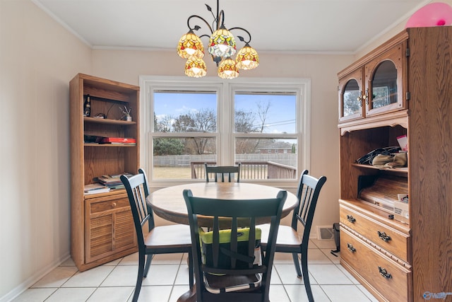 dining area with crown molding, light tile patterned flooring, and an inviting chandelier