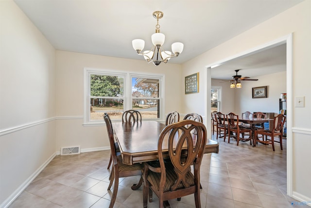 tiled dining area with ceiling fan with notable chandelier