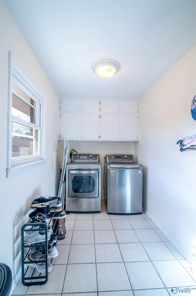 laundry room featuring cabinets, independent washer and dryer, and light tile patterned floors