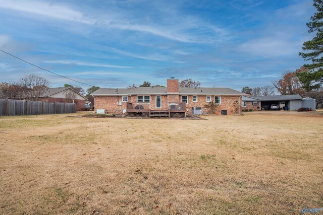 rear view of property featuring a lawn and a deck