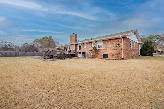 rear view of property featuring a lawn and a deck