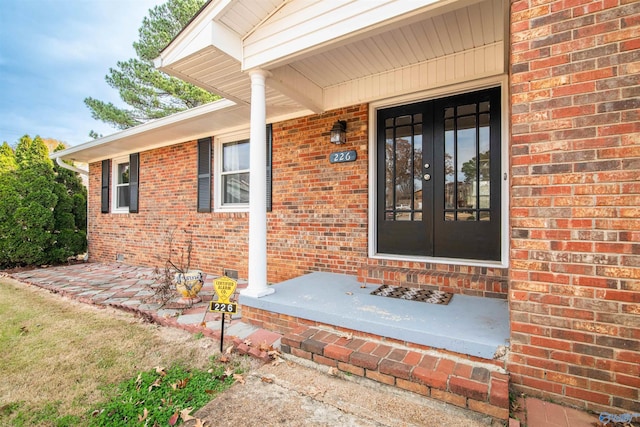 view of exterior entry with french doors and a porch