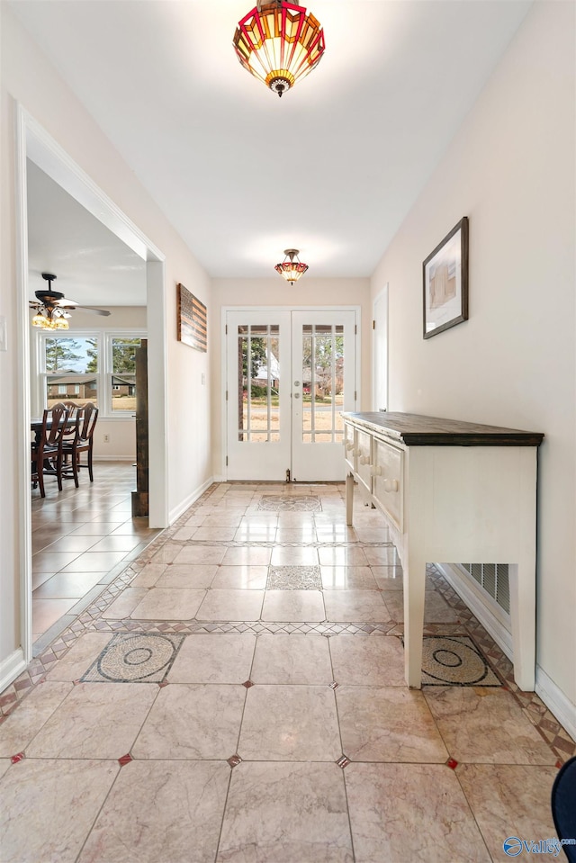 foyer featuring ceiling fan and french doors