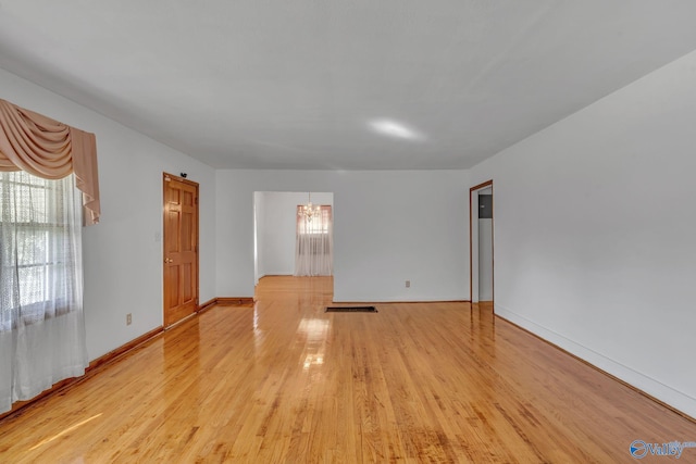 1013 Hermosa Ave, Gadsden, AL 35901 - empty room featuring visible vents, baseboards, light wood-type flooring, and a notable chandelier