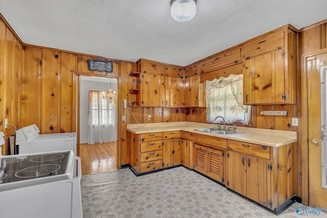 1013 Hermosa Ave, Gadsden, AL 35901 - kitchen with washer / clothes dryer, a sink, light countertops, brown cabinets, and wood walls