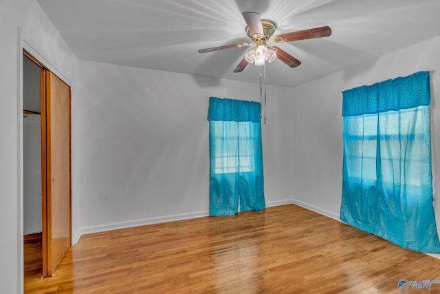 empty room with ceiling fan and light hardwood / wood-style flooring