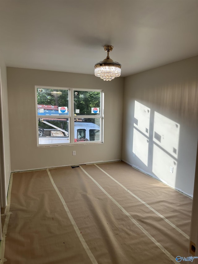 unfurnished dining area featuring baseboards, an inviting chandelier, plenty of natural light, and carpet