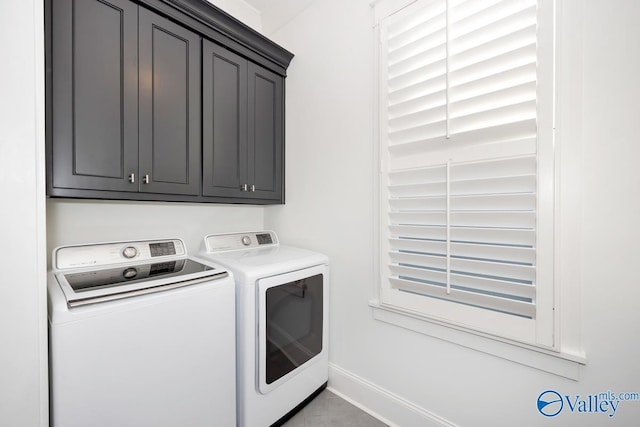 laundry area featuring baseboards, separate washer and dryer, and cabinet space
