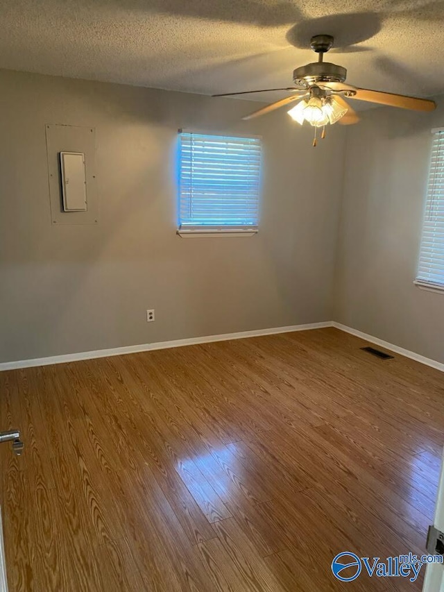 1520 Balch Rd, Madison, AL 35757 - empty room featuring wood finished floors, ceiling fan, a textured ceiling, baseboards, and electric panel