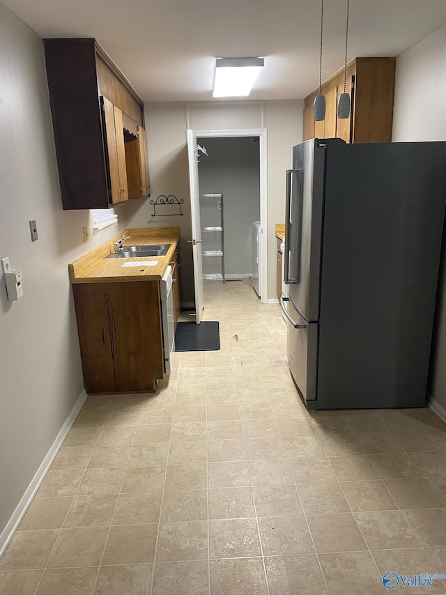 1520 Balch Rd, Madison, AL 35757 - kitchen with freestanding refrigerator, a sink, light countertops, washer / dryer, and light tile patterned floors