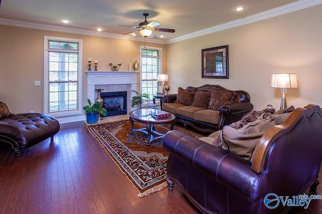 living room with dark wood-type flooring, ornamental molding, a fireplace, and ceiling fan