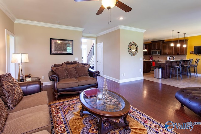 living room with ornamental molding, sink, ceiling fan, and hardwood / wood-style floors