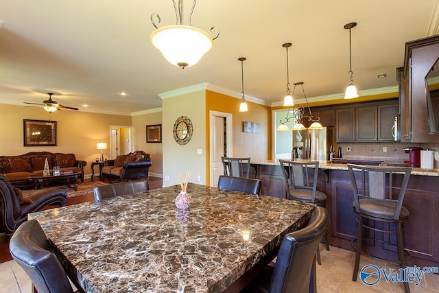 tiled dining area featuring crown molding and ceiling fan