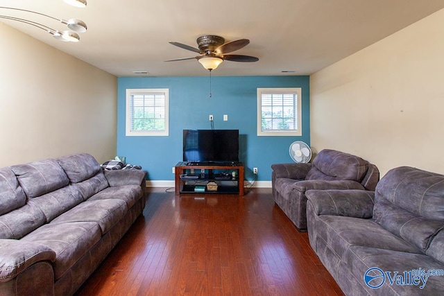 living room with dark wood-type flooring, ceiling fan, and a healthy amount of sunlight