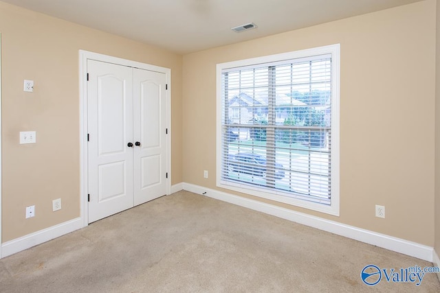 unfurnished bedroom featuring a closet and light carpet