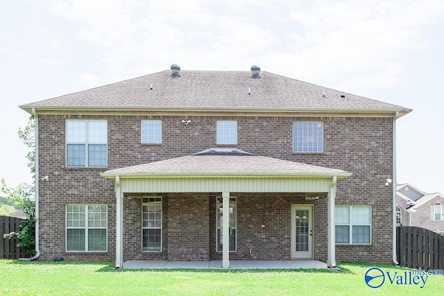 back of house with a patio and a lawn