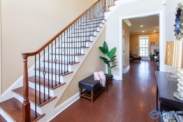 stairs with crown molding and hardwood / wood-style flooring