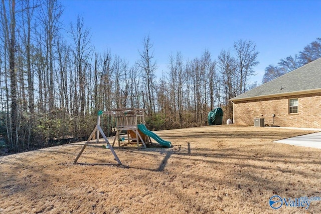 view of play area with central AC unit and a lawn