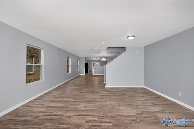 unfurnished living room with light hardwood / wood-style flooring and a chandelier