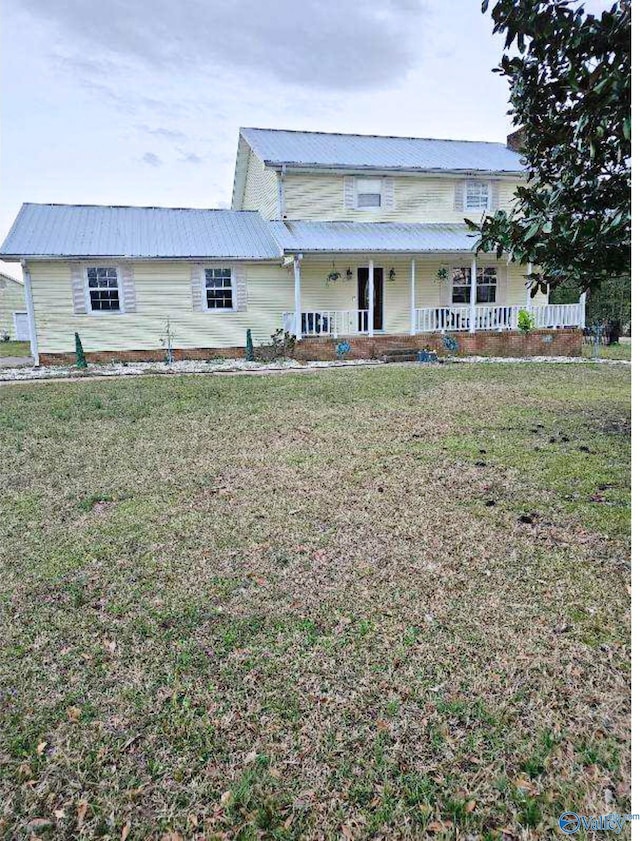 view of front of property featuring a porch, a front lawn, and metal roof