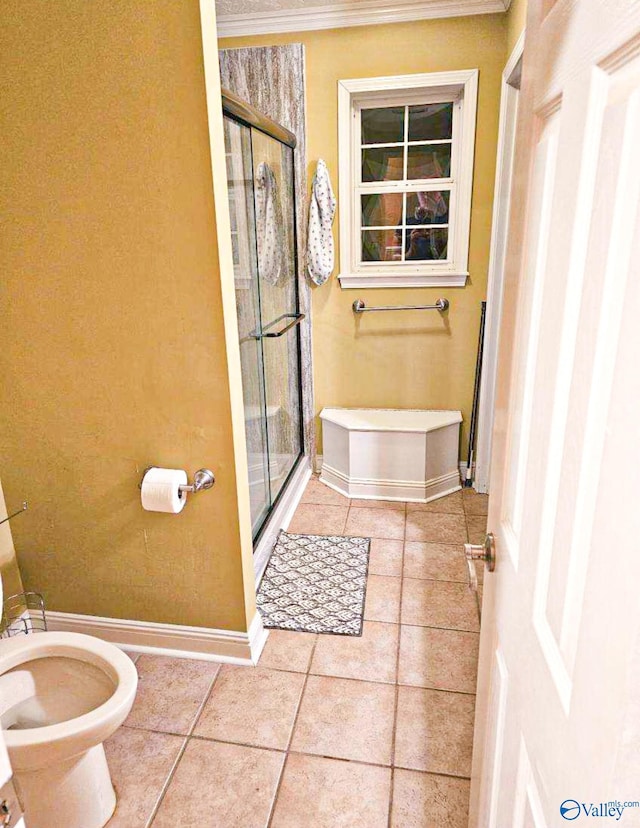 full bathroom featuring a shower stall, tile patterned flooring, baseboards, and ornamental molding